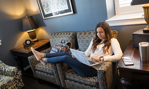 a girl sits and reads on a couch