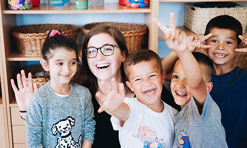 A student surrounded by smiling kids