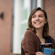 picture of a girl holdig books smiling