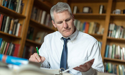 male student studying in library on college campus