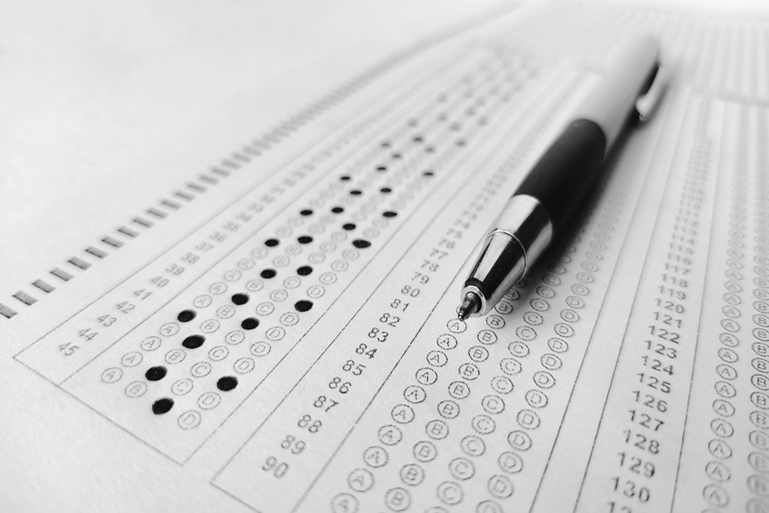 picture pencil laying on scantron for either the SAT test or the ACT test