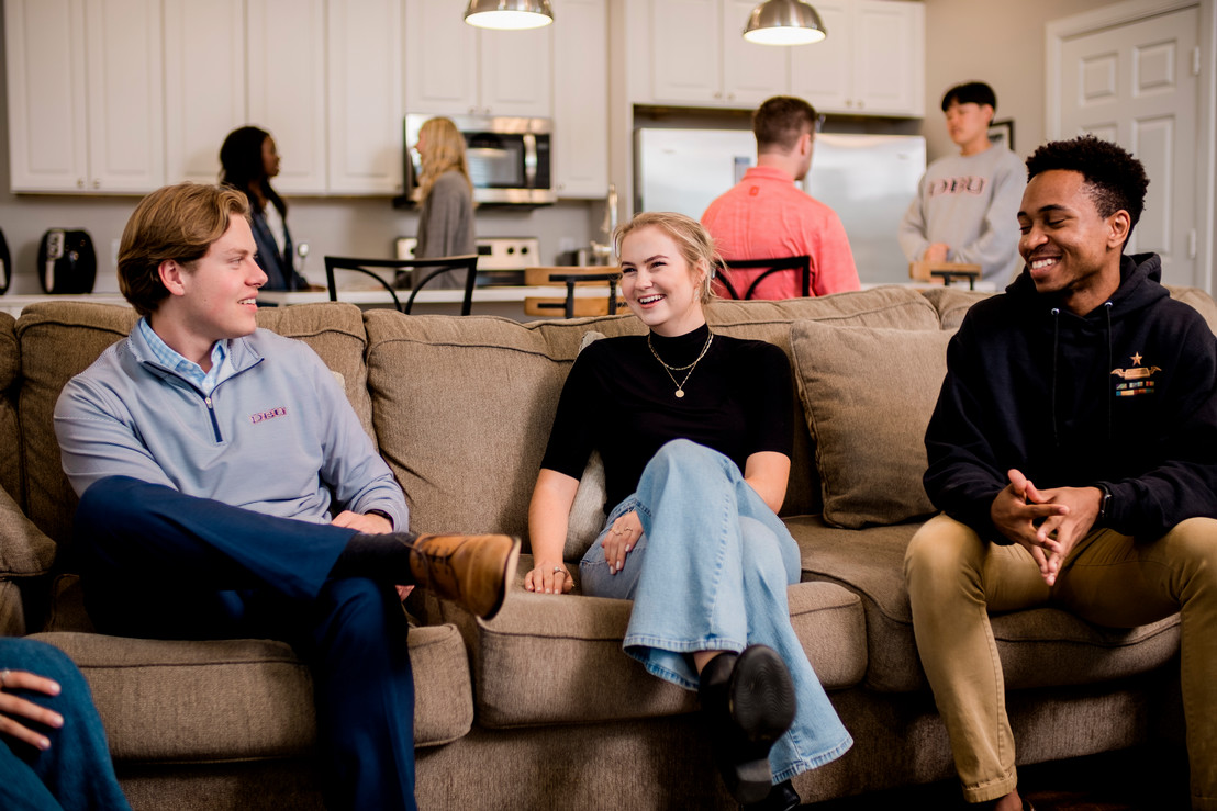 group of college friends sitting on a couch talking in Dallas, Texas