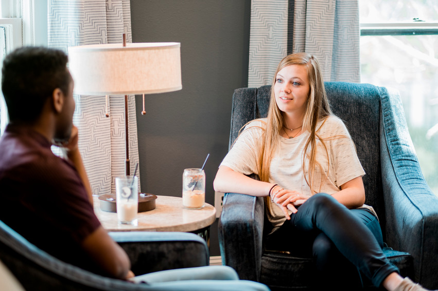 Girl in Dallas, Texas siting in chair talking with man