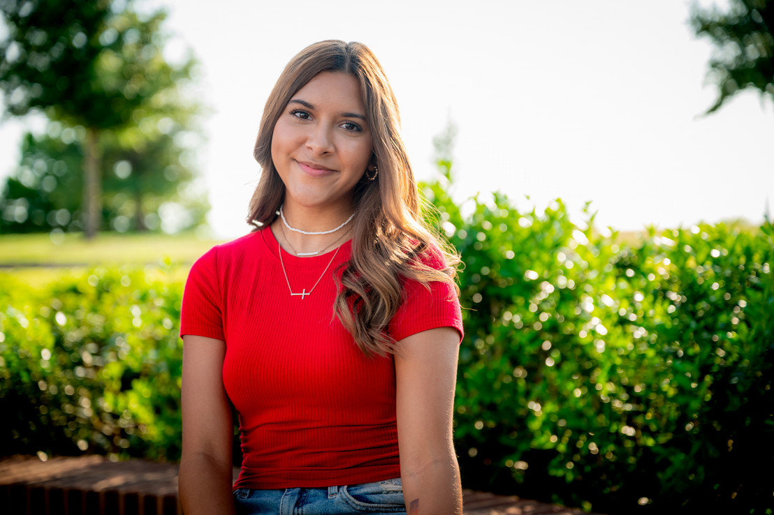 college female student standing outside in red shirt in Dallas, Texas