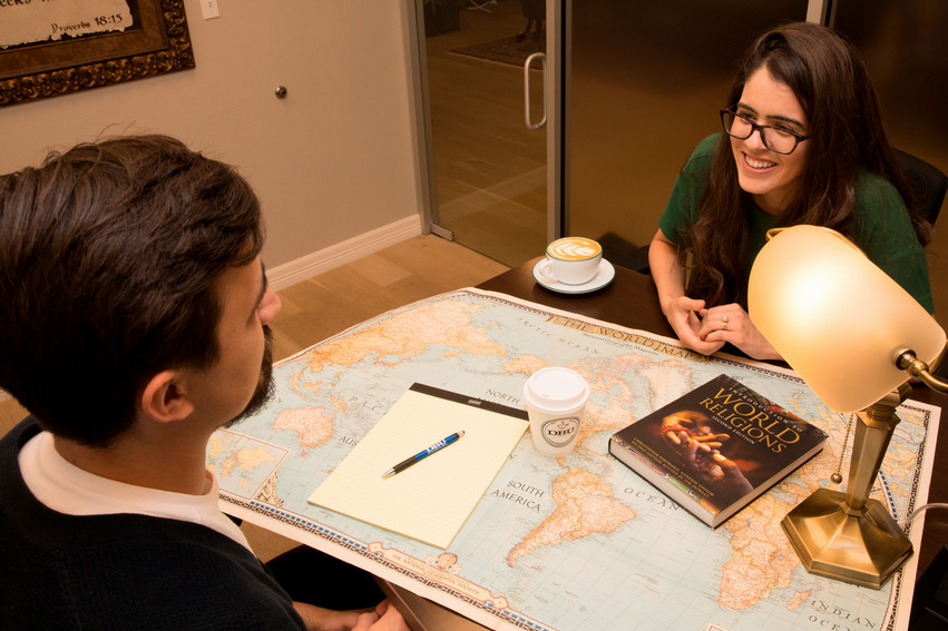 college students meeting in a coffee house in Dallas having a conversation with a book on the table