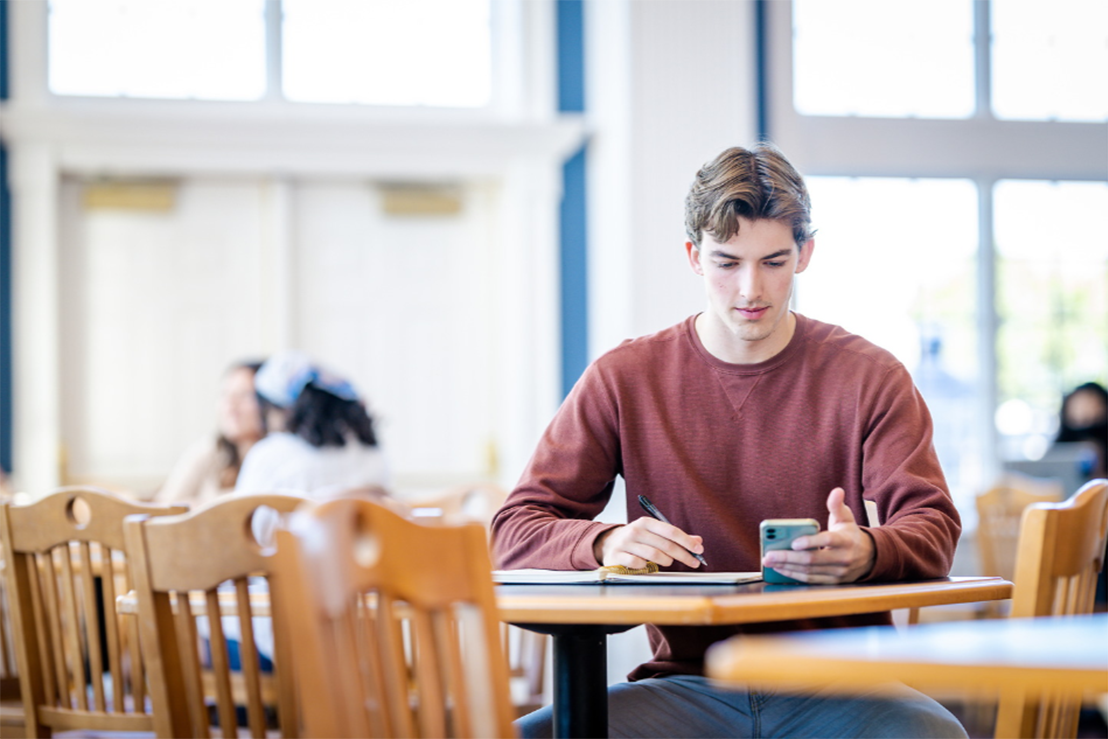 college student in Dallas, Texas, sitting at table working on his budget