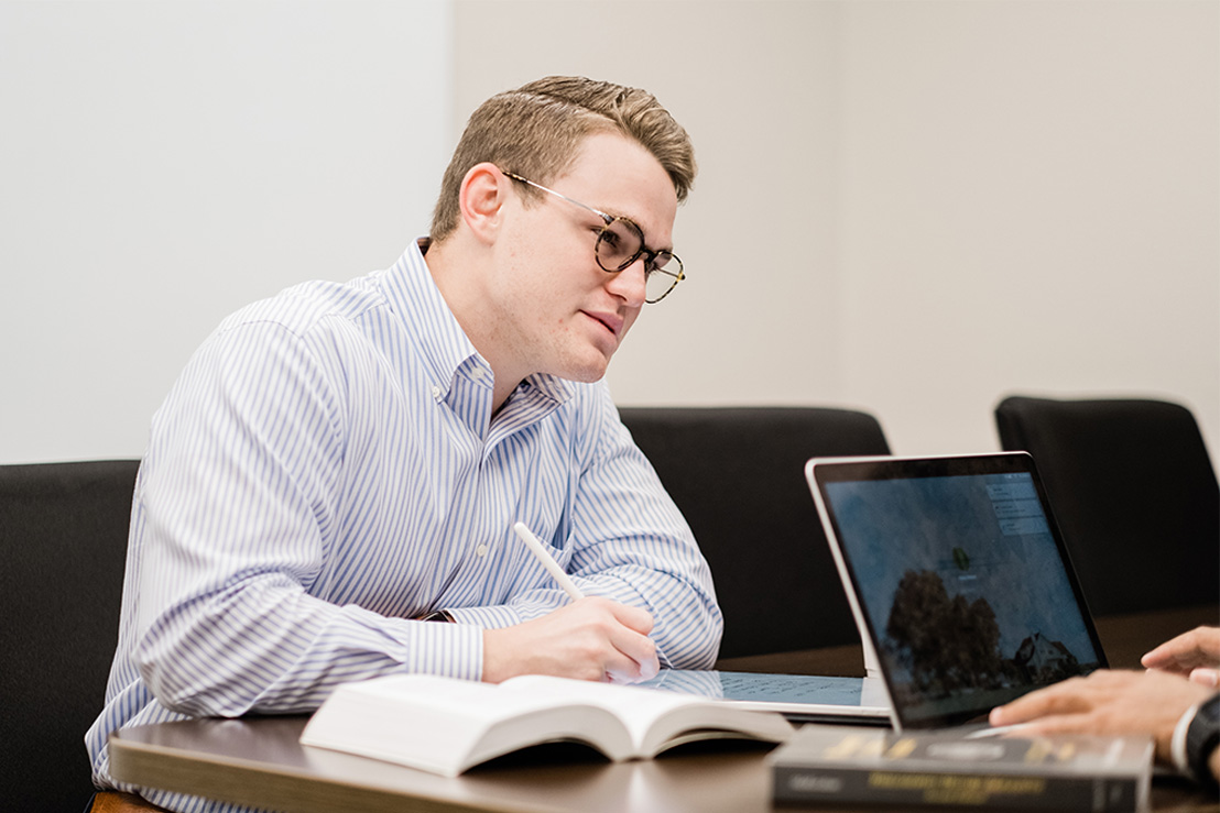 college student taking notes in a business meeting in Dallas, Texas