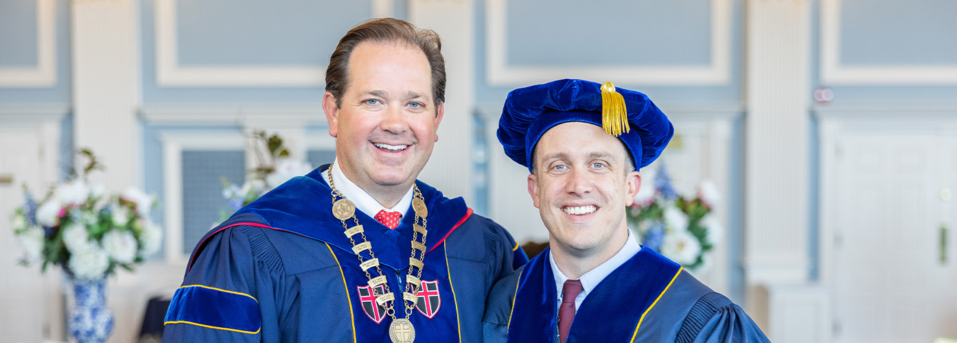 Dr. Wright is shaking hands with a graduating doctoral student. 