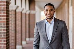 man smiling and wearing grey suit