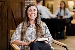 girl smiling and sitting in chair at the DBU coffeehouse