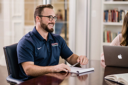 man sitting in a classroom smiling