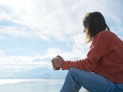 Girl sitting by the ocean