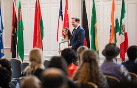 Adam Wright standing with student with flags in background