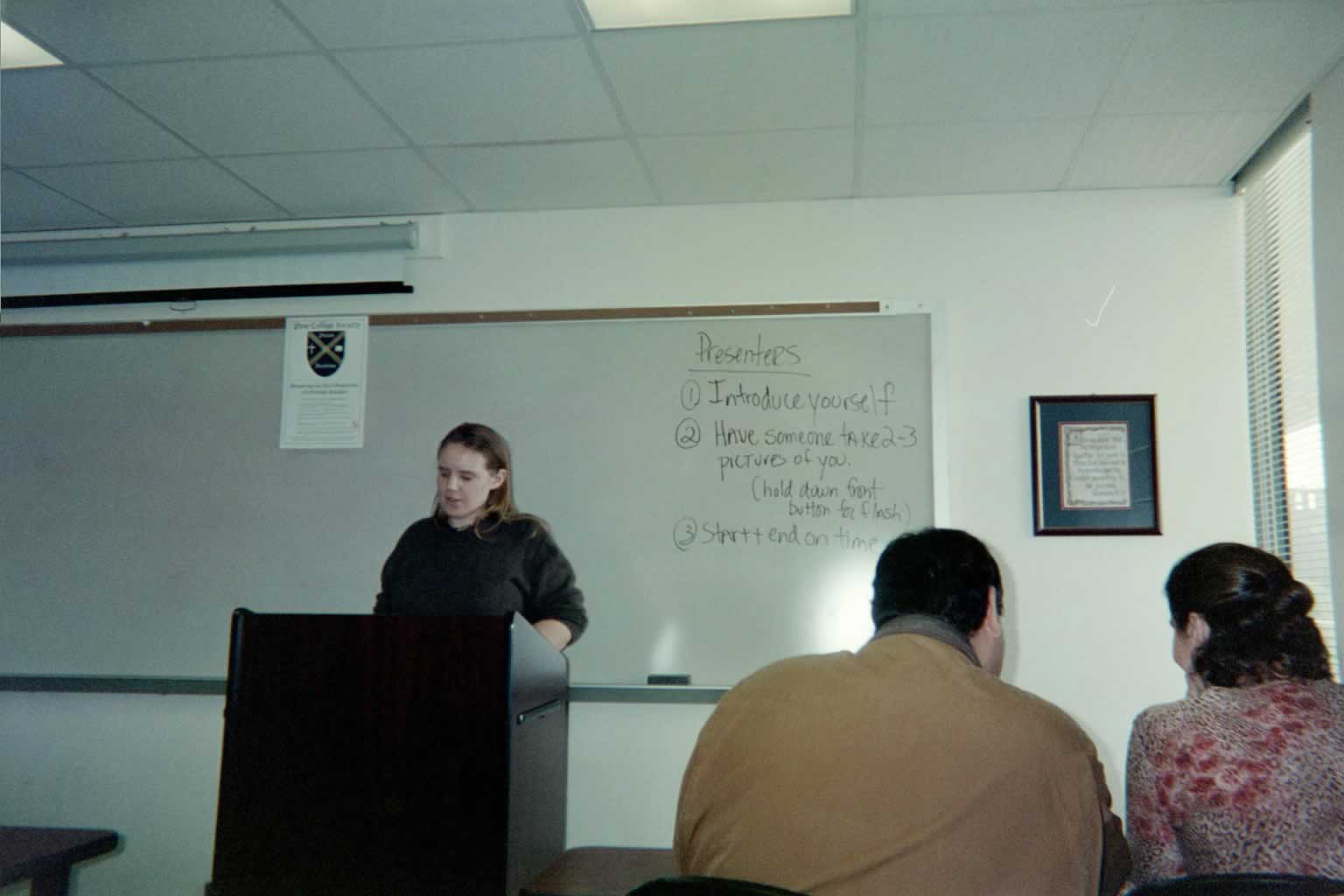 picture of a woman standing behind a podium looking down