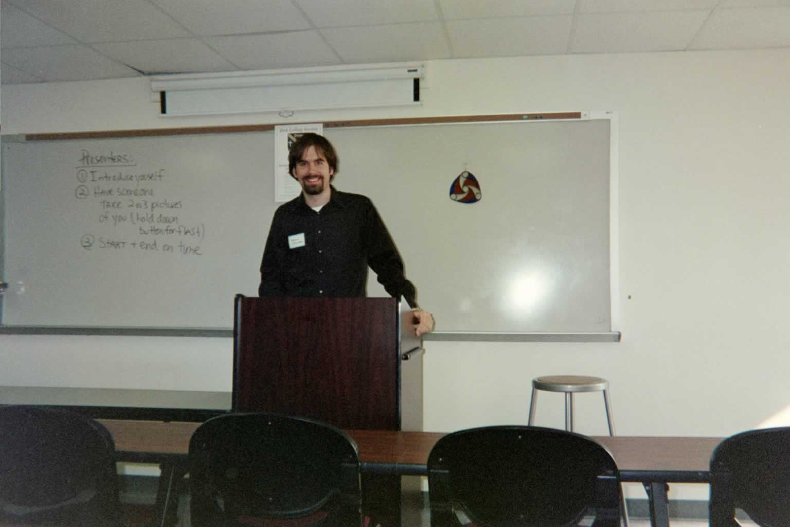 picture of a man standing behind the podium smiling