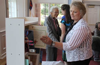 picture of a woman pulling out a book off a shelf in the Great Hall