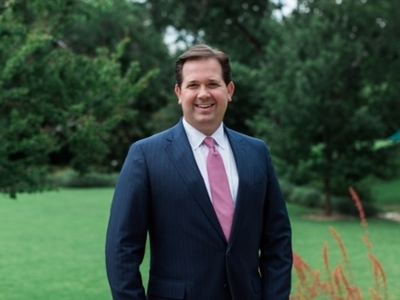 Dr. Wright is standing in front of trees, smiling. 