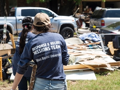 A girl carries debris to a pile