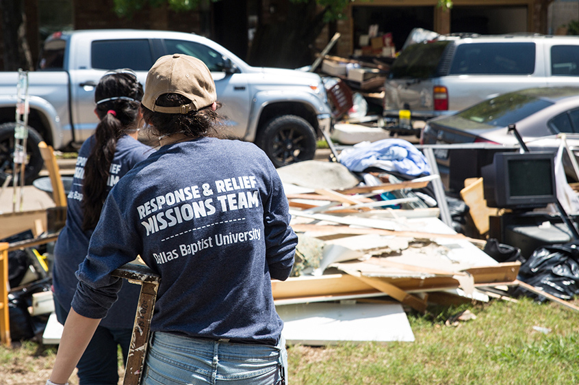 A girl carries debris to a pile