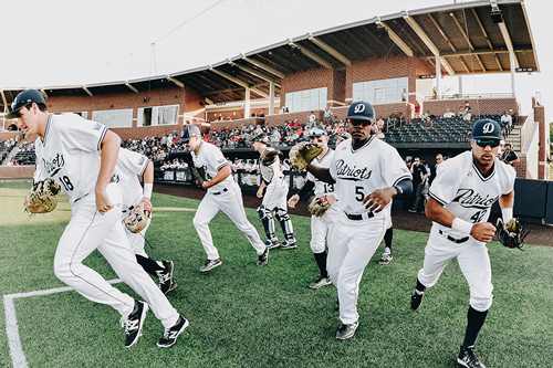 DBU baseball players running on to the DBU baseball field.