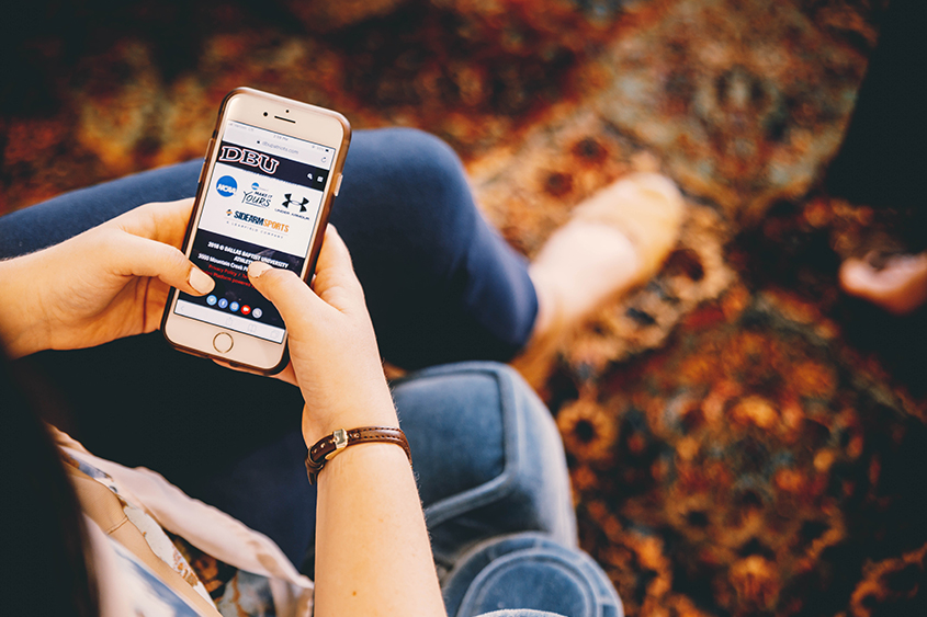 A girl scrolls through webpages on her smartphone