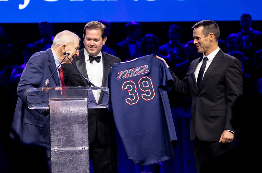 Dr. Adam Wright and Dan Heefner present Sam Johnson with DBU Baseball jersey