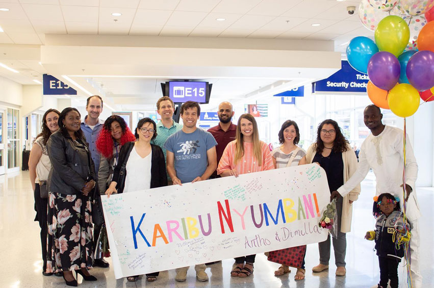 Angela Hayward with group of people holding sign at airport