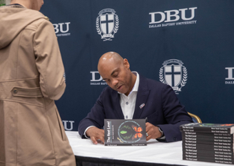 picture of Dr. Goodloe signing his book