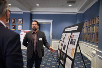 picture of Jon Dooley standing next to a posterboard