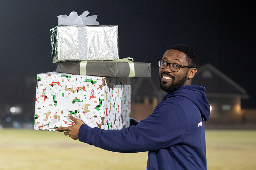 DBU student holding Christmas gifts