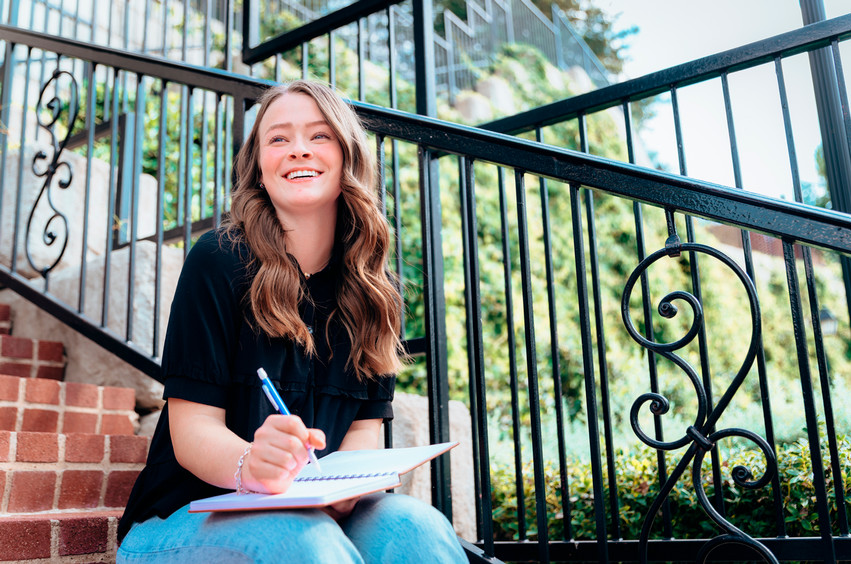 college student sitting in dallas outside her brownstone