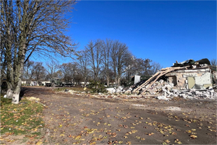 remains of destoryed buildings with trees and blue sky