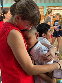 DBU girl athlete hugging a Costa Rican student