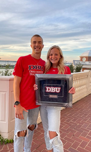 Reese and Yale standing together at DBU with sunset in background