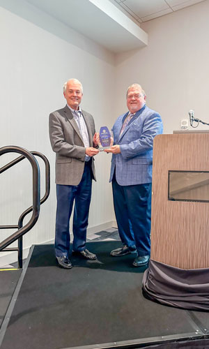 Dr. Gary Cook holding award with Dr. Bobby Hall