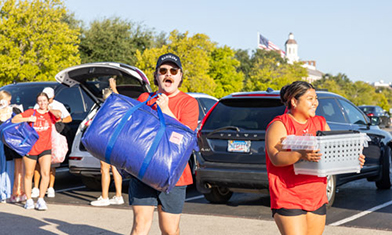 students helping carry freshmen belongings