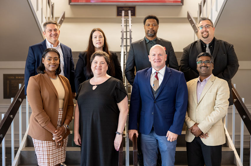 DBU's Newest Faculty Members standing on the stairs of the Collins Learning Center in Dallas, Texas