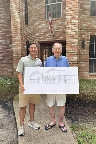 John Austin Earles & older man stand in front of a house holding a Westbrook Building Company sign