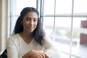 smiling girl sitting next to the window