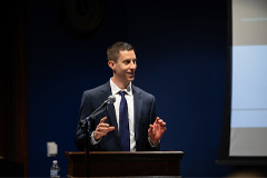 man in suit standing at the podium talking