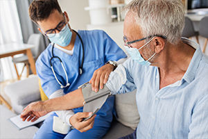 nurse taking an elderly man's blood pressure