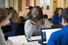 picture of a woman talking to her friend in a studious area 