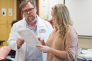  professor looking at paper with student