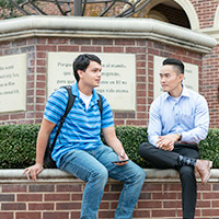 international students sitting in front of DBU globe statue